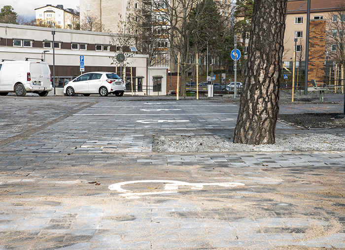 Bild på p-platser för rörelsehindrade. Målat på asfalten är ikonen för rullstol.