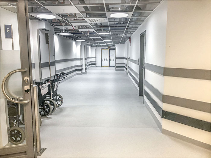 En tom korridor förutom att två rullstolar står längst ena väggen.