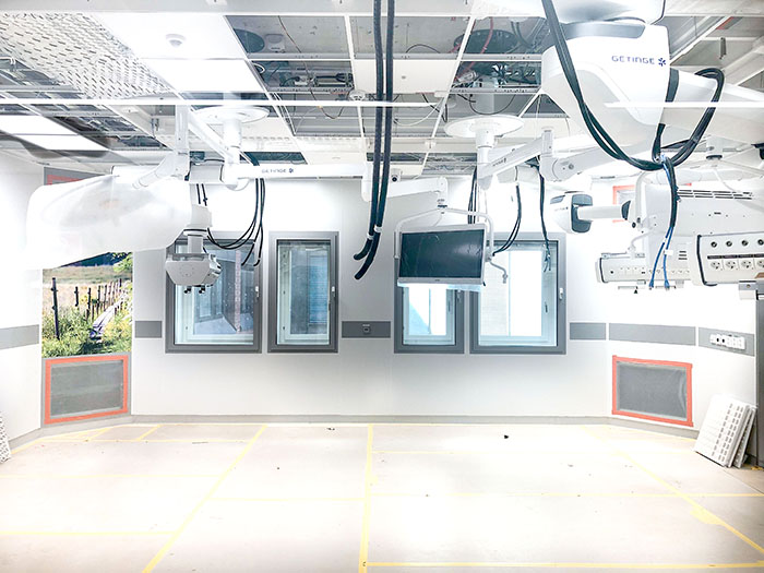 Byggbild: En operationssal. i taket hänger det ned kablar som ska anslutas till kommande utrustning.