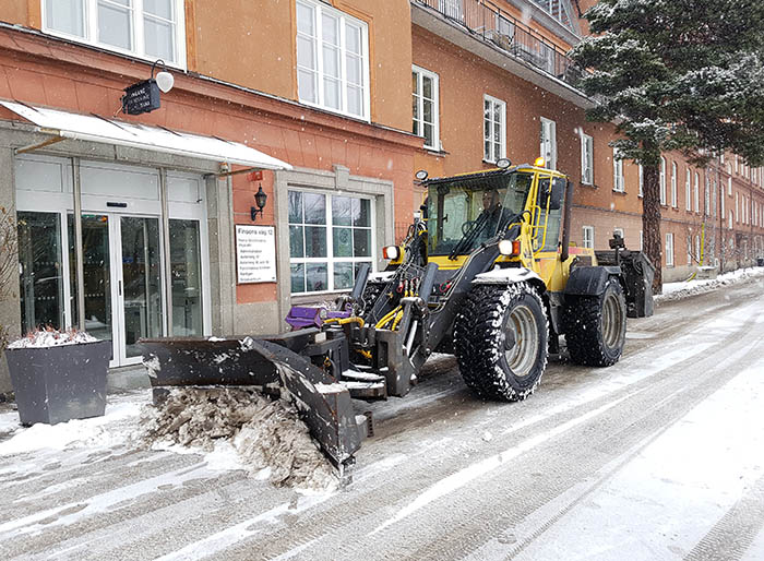 Traktor som som flyttar på snön med skopan