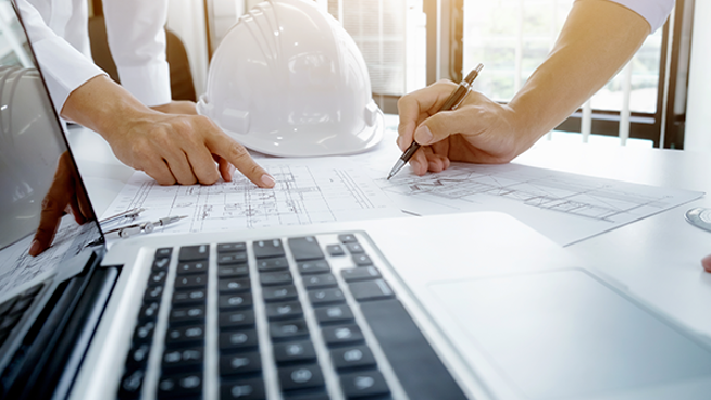 Bild med laptop, ritning och två händer som pekar och ritar.