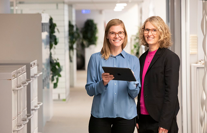 Två kvinnor som ler mot kameran.