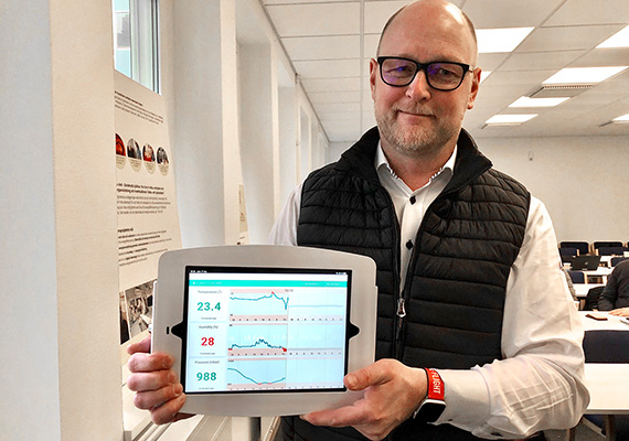 Thomas Ahlberg med en iPad som visar  grafer