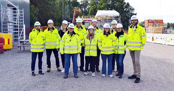 Gruppfoto av män och kvinnor i varseljackor och bygghjälmar.
