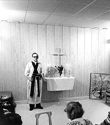 En präst som predikar i ett andligt rum på ett av våra sjukhus.