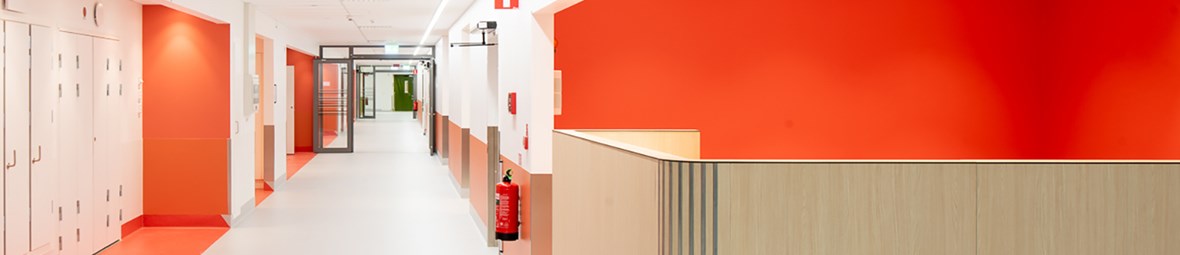 Korridor med röda detaljer i sjukhus.