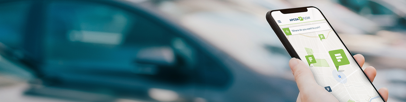 En hand som håller i en mobil som visar en parkeringsapp.