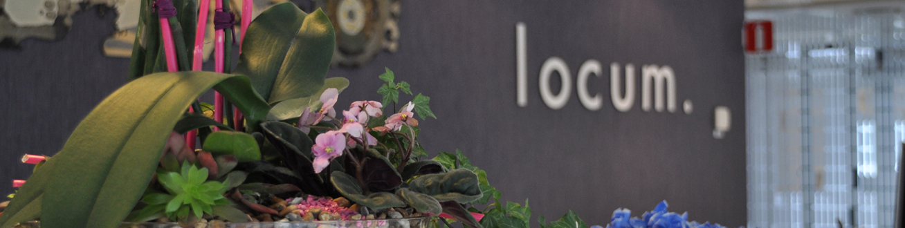 Bild på receptionsdisken på Locums huvudkontor på Östgötagatan 12. I förgrunden syns ett blomsterarrangemang. 