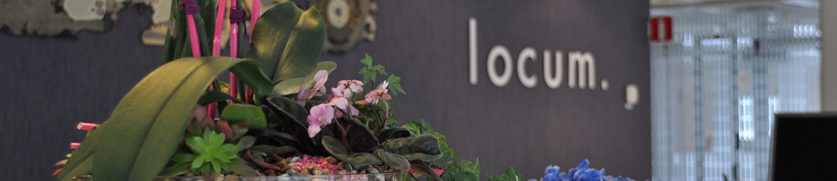 Bild på receptionsdisken på Locums huvudkontor på Östgötagatan 12. I förgrunden syns ett blomsterarrangemang. 